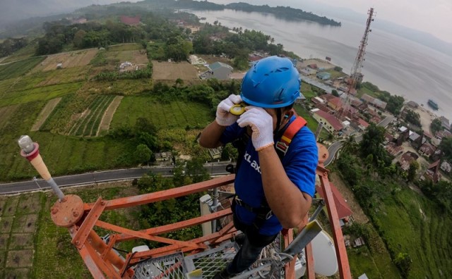 Teknisi XL Axiata bekerja di atas menara BTS di kawasan Danau Toba, Samosir, Sumatera Utara, beberapa waktu lalu.